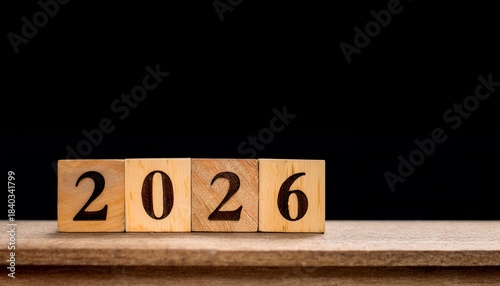 Wooden block with 2026 type on black background copy space Happy new year concept