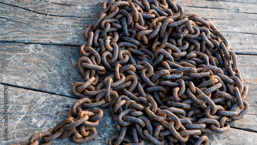 An old rusty metal chain stands on planks