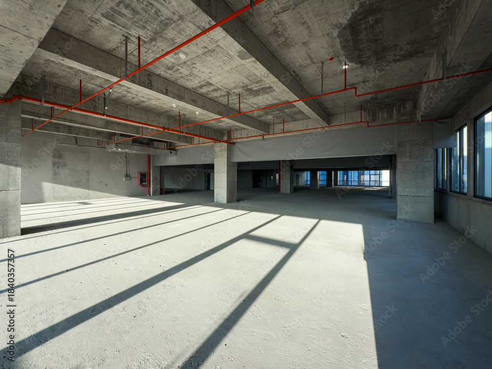 Fototapeta premium Exploring the Vast Potential of an Empty Industrial Space Bathed in Natural Light