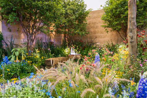 фотографія Tranquil Garden Oasis Surrounded by Beautifully Blooming Wildflowers