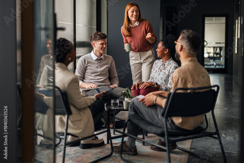 Fotografie Group of Professionals Having a Positive Discussion in a Modern Office Space