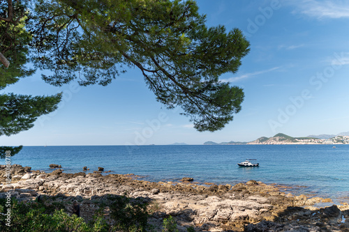 Clear blue waters gently lap against the rocky coastline of Lokrum island, Croatia.