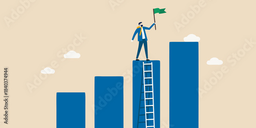 A businessman celebrates success atop a bar graph with a green flag