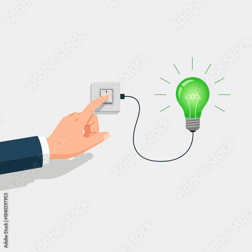Hand pressing a light switch to turn on a glowing green energysaving light bulb, concept of idea, innovation, and electricity saving