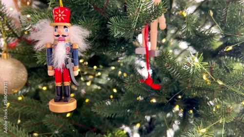 Wooden soldier Christmas ornament hanging on a decorated Christmas tree. Traditional holiday decor with festive lights and classic New Year atmosphere, winter celebration and seasonal decoration.