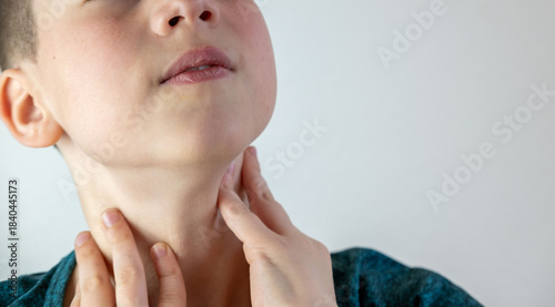 Foto Teen boy holding sore throat, voice loss, painful swallowing, adolescence change