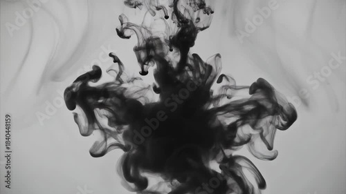 Abstract black ink swirling and spreading dynamically in clear water creating intricate organic fluid patterns and textures against a light background artistic motion science concept