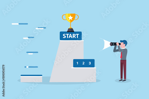 A man looks through binoculars towards a trophy on a starting platform