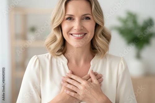 Smiling woman facing camera with hands over heart expressing gratitude Free Download Smiling woman facing camera with hands over heart expressing gratitude - GFXLoad