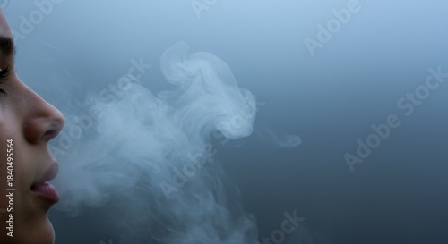 Woman Exhaling Smoke Against a Blue Grey Background