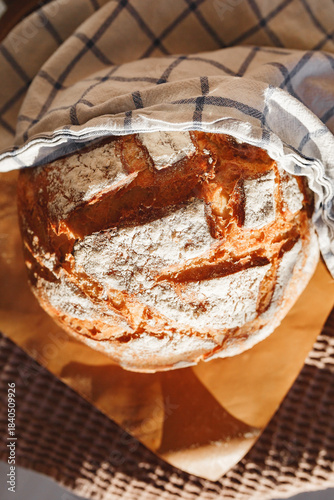Freshly baked artisanal bread under a checked cloth