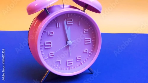 Pink alarm clock running backwards 