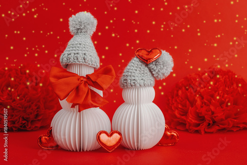 Snowmen couple in love with handmade felt heart. Festive greeting card concept, Valentine's Day