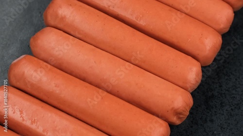 Heap of sausages on plate preparation for cooking, rotation
