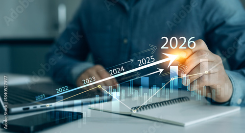 Businessman analyzing financial growth chart for 2026 year.Showing revenue increase, market trends, investment strategy, economic progress, success and future business development in 2026.