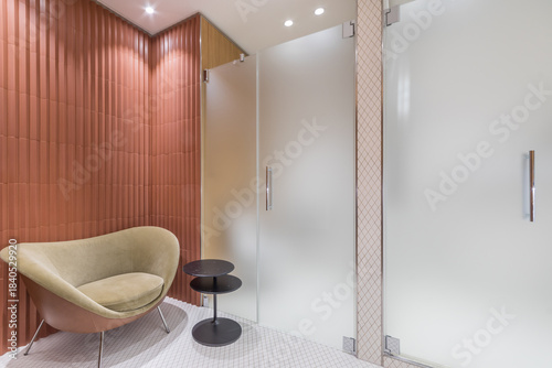 Billede på lærred This setting features a contemporary bathroom design with a unique chair and a small table