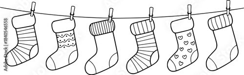 Six black and white line Christmas stockings hanging on a clothesline holiday