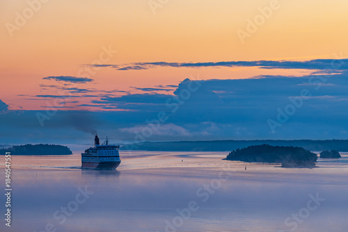 Fährschiff mit Nebel und Sonnenaufgang im Schärengarten vor Stockholm, Schweden