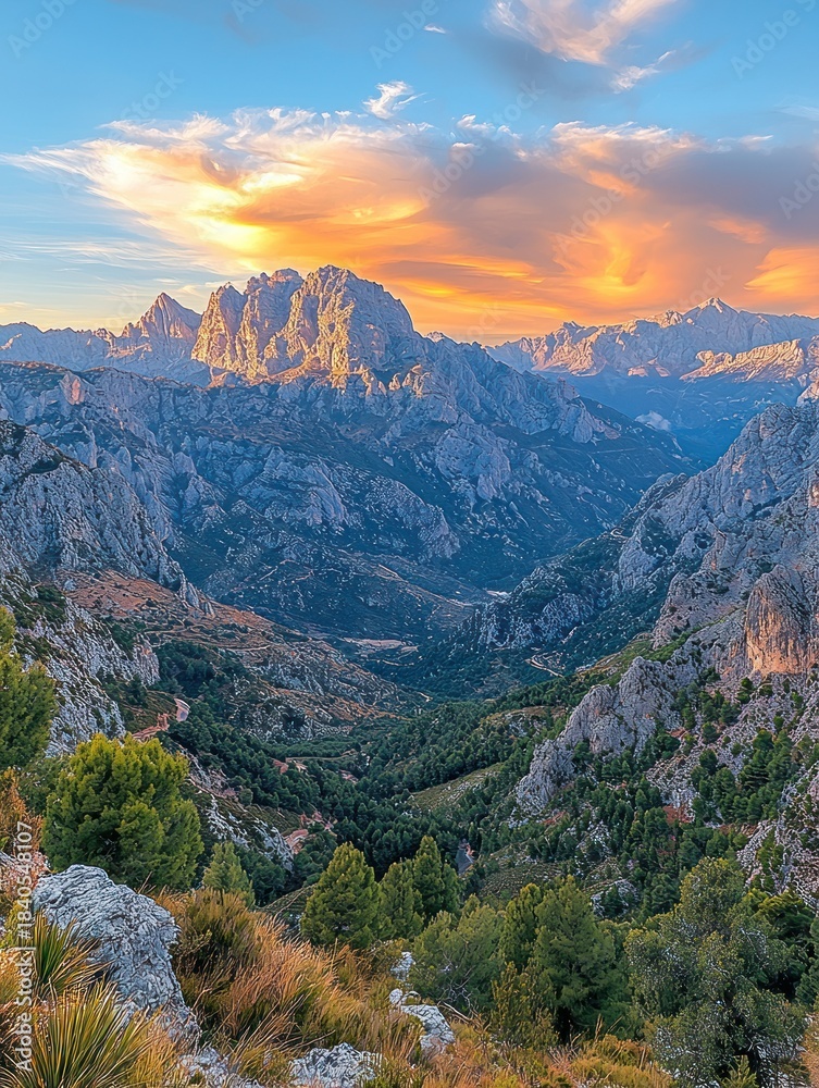 Fototapeta premium Majestic mountain range bathed in golden sunset light over a valley