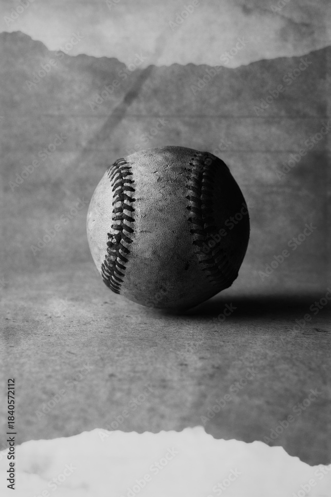Obraz premium Old vintage baseball with torn paper texture background in vertical view for sport.