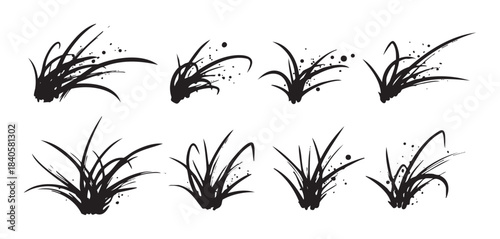 Stylized grass illustrations created with expressive ink brush strokes and artistic splatters, forming a versatile graphic element set.