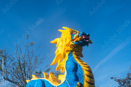 Dettaglio di una giorstra per bambini a forma di drago blu e giallo con il cielo sullo sfondo