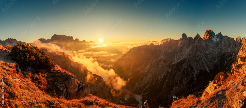 Fototapeta premium Majestic golden sunrise over mountain ridge and foggy in Cadini di Misurina, Dolomites, Italy