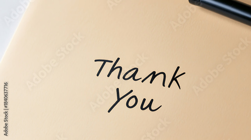 A handwritten note expressing gratitude with simple elegance. The phrase 'Thank You' is prominently displayed on a neutral background, creating a sincere and appreciative message.