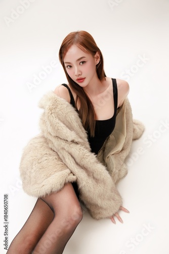 Confident Glamorous Asian Woman Posing in Luxury Fur Coat Ready for a Party.