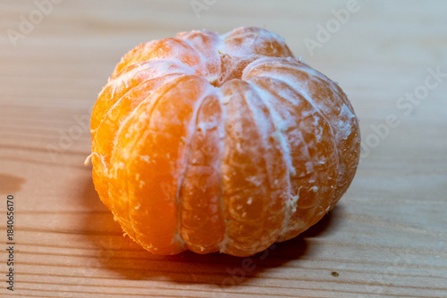 Fresh orange citrus fruit with textured skin resting on a wooden surface, showcasing vibrant color and natural beauty, ideal for healthy lifestyle and nutrition concepts