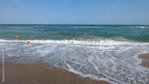 Afternoon waves gently wash over the sandy beach