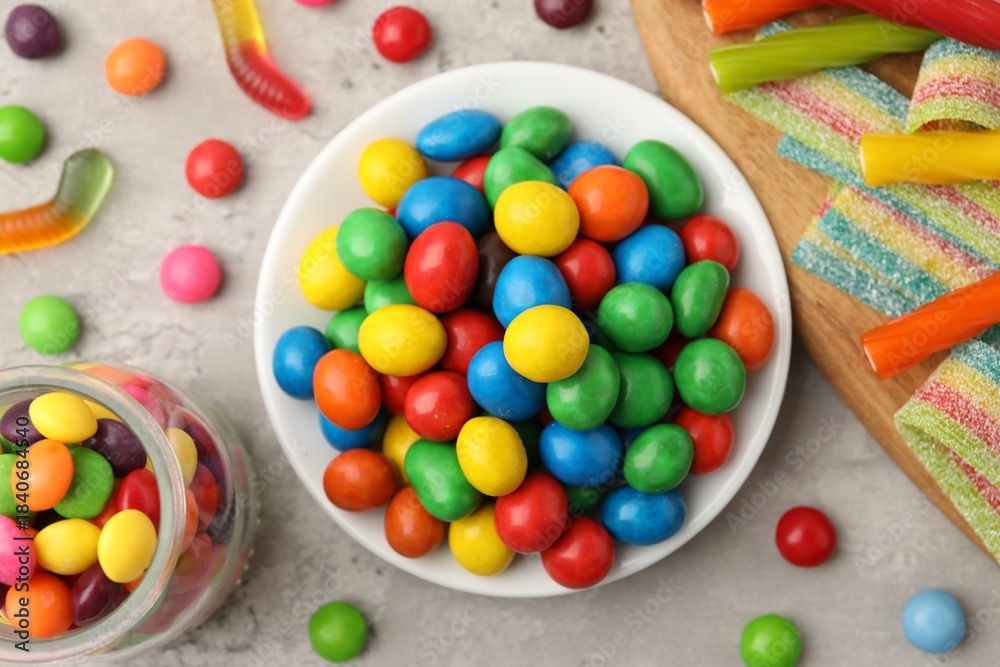 Fototapeta premium Delicious colorful candies on light table, flat lay