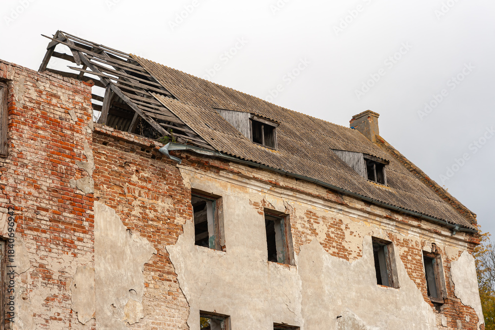 Ταπετσαρία Exterior of an old, abandoned, and derelict brick and stucco building with a partially collapsed slate roof and crumbling walls against a white sky, symbolizing decay and abandonment
