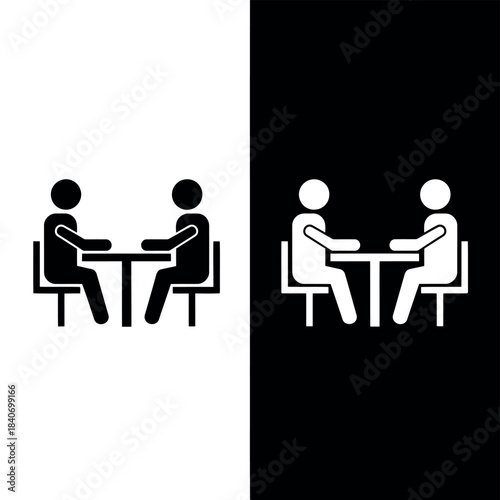 Two stick figures in black and white halves of the sitting at tables facing each other