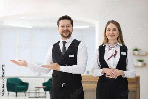 Foto Receptionist and hostess near reception desk indoors