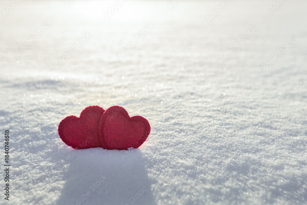 Fototapeta premium two red hearts on white fresh snow, love heart concept, valentine's day card,