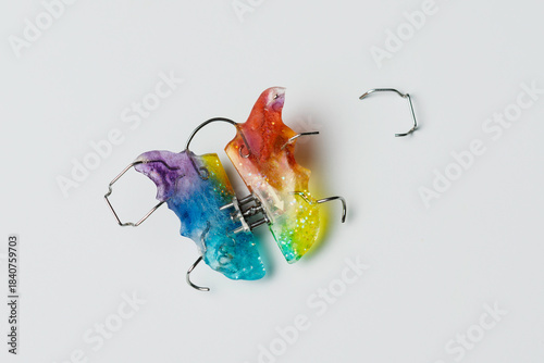 Foto Colorful orthodontic retainer lies broken on white background, symbolizing denta