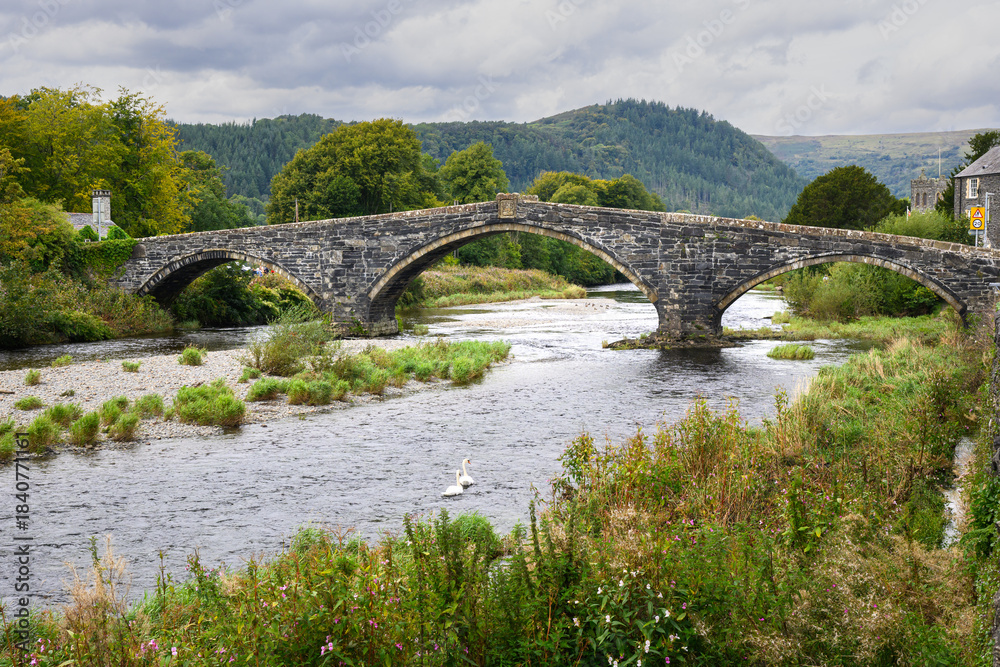 Fototapeta premium Llanrwst Bridge Pont Fawr crossing River Conway in North Wales landscape