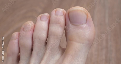 Perfect male foot with uncut nails. Beautiful foot and toes of an adult man. Man wiggles his toes