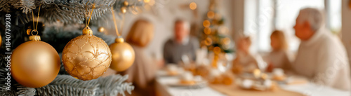 Golden Christmas Ornaments with Family Celebrating in Background.