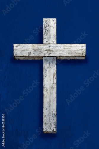 Croce di legno sbiancato, vintage,  posta contro un vibrante sfondo blu cobalto, evocando un senso di semplicità e spiritualità.