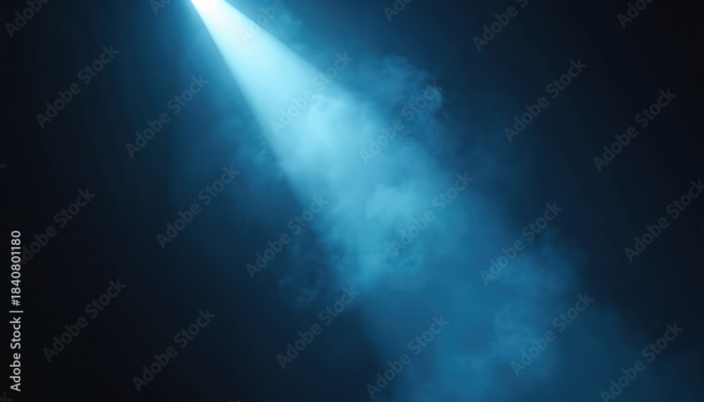 Fototapeta premium Bright blue spotlight beam cuts through dark smoky room, creating dramatic atmosphere. Light shines down from above illuminating haze, making abstract background.