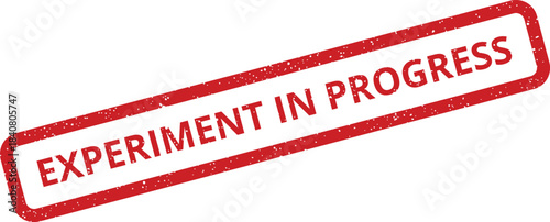 A distressed red rectangular rubber stamp illustration indicating an experiment is currently underway or being developed