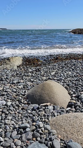 Ocean waves crashing into rocky beach vertical video