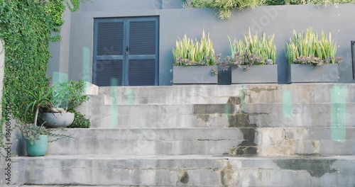 On play camera rising to show louver door and planters on steps while teal streaks drifting