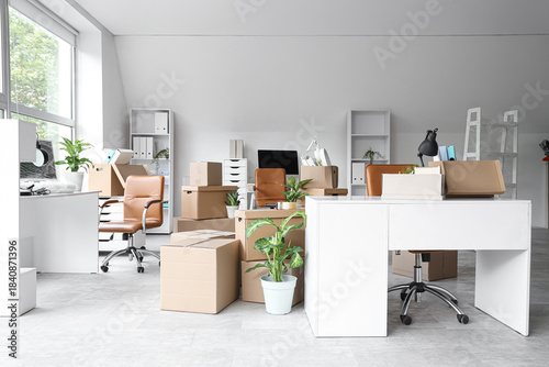 Fotografía Desks with cardboard boxes in office on moving day