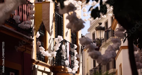 Beautiful white garland hangs across the street in the historic old city of Seville, Andalusia, Spain.