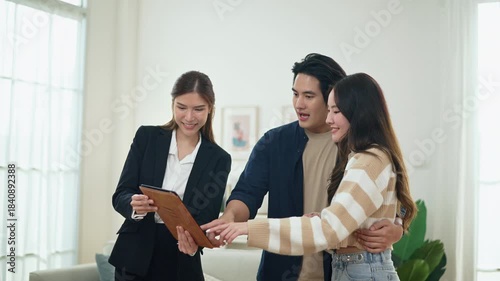 Asian financial consultant explaining new project investment to young couple in office. Real estate agent discussing mortgage options with family. Mortgage loan consultation with financial advisor.