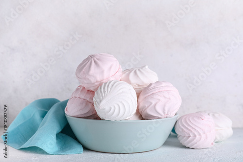 Photos Bowl with sweet marshmallows on table against white background