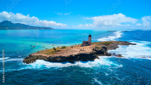 A stunning aerial view of Île aux Fouquets National Park in Mauritius, featuring an old ruined lighthouse on the island with panoramic views of the surrounding turquoise waters and lush landscapes.